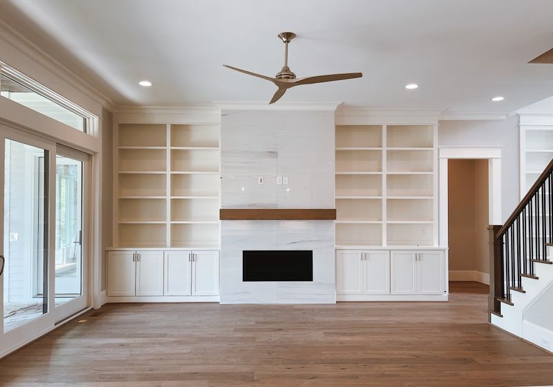 Custom built-in media wall with white cabinets and floating wood shelves